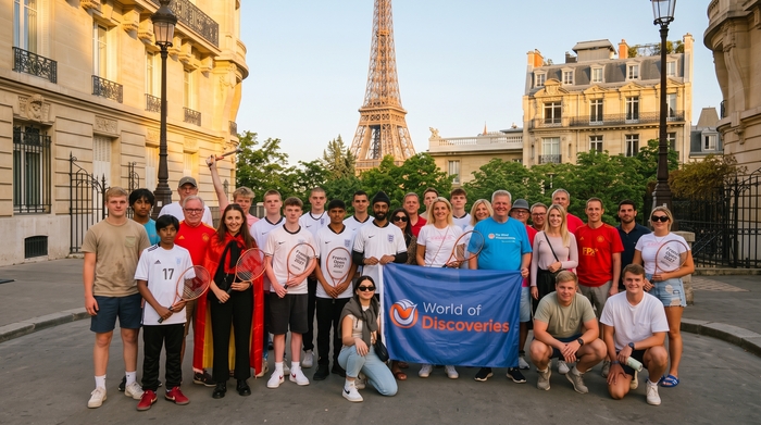World of Discoveries French Open 2027 tour group posing with tennis rackets near the Eiffel Tower, Paris.